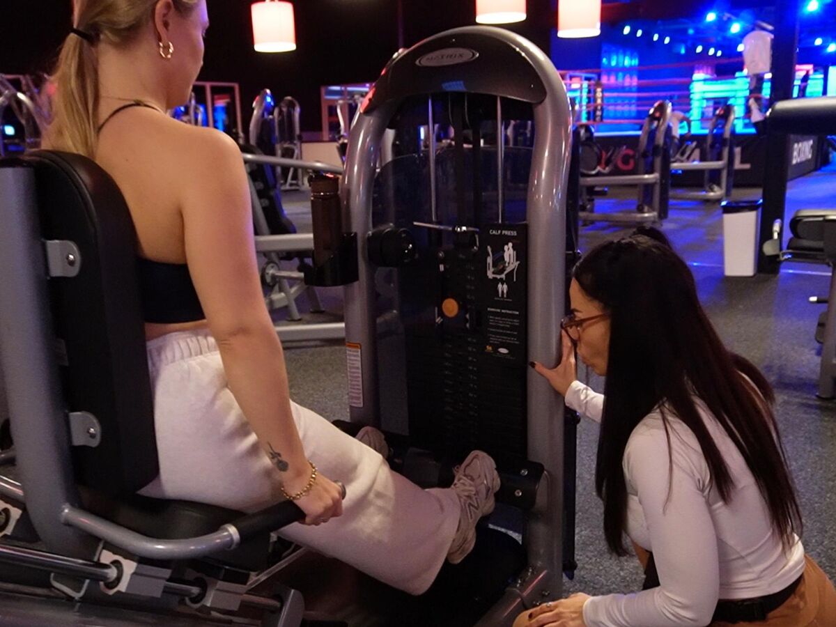 Esmeralda begeleidt een klant bij de calf press tijdens een 1-op-1 training bij BigGym
